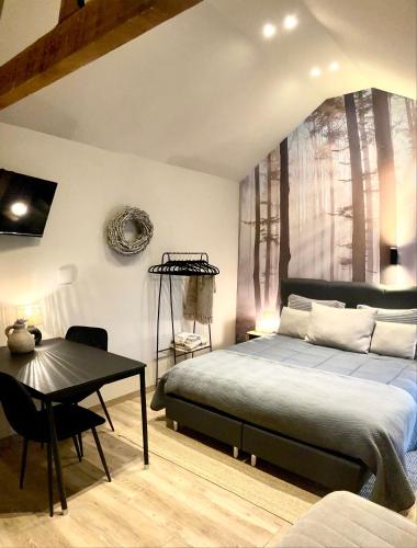 a bedroom with a bed and a desk and a table at Het Roerhofje in Herkenbosch