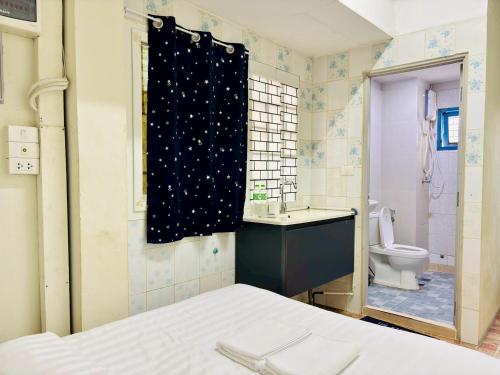 a bathroom with a toilet and a shower curtain at BKK Rama3 Guest House in Bangkok