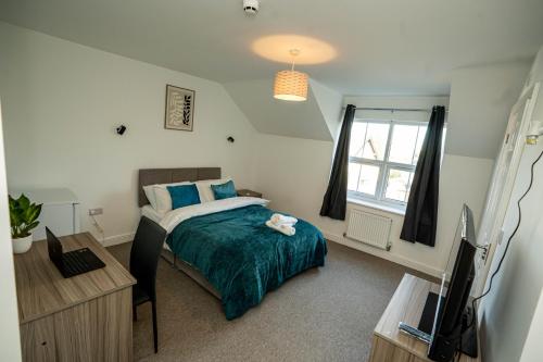 a bedroom with a bed and a tv in it at Queens Court Ensuite Studio in Stoke on Trent