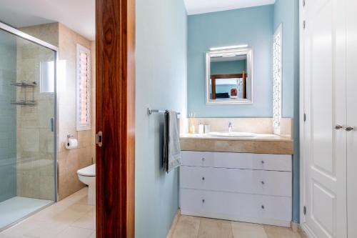 a bathroom with a sink and a toilet and a mirror at Villa Cornelia in Adeje