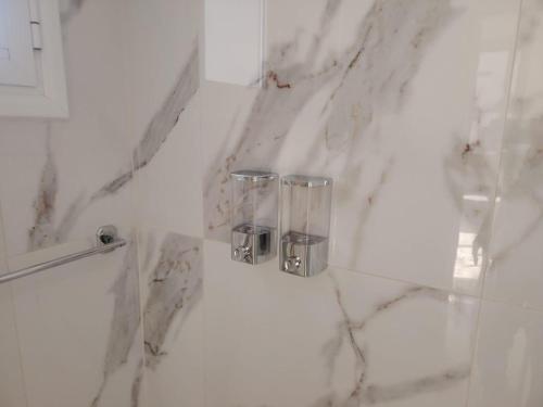 a bathroom with white marble walls and chrome fixtures at Horizon Bliss at Coral Bay in Peyia