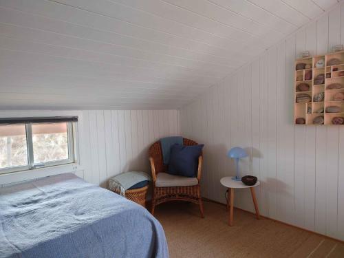 una camera da letto con un letto, una sedia e una finestra di Lovely Summer House On Natural Grounds a Frøstrup