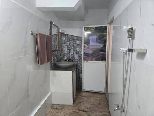 a white bathroom with a sink and a shower at The Coast Haven in Tangalle