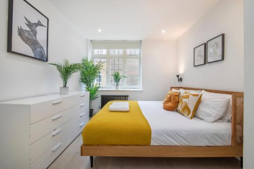 a bedroom with a bed with a yellow blanket at Welcome Shoreditch, 1 Bed 1 Bath London Apartment in Superb Location in London