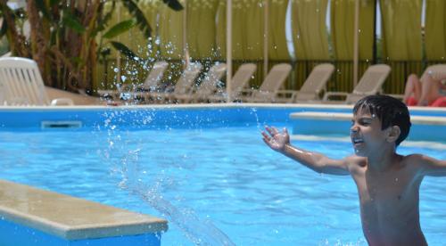 a young boy playing in a swimming pool at Kikki Village in Modica