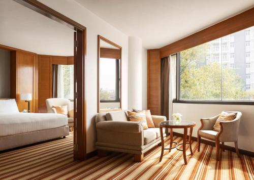 una stanza d'albergo con un letto, un tavolo e delle sedie di Amari Don Muang Airport Bangkok a Bangkok