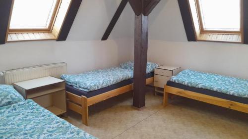 three beds in a room with three windows at Apartmány SRC in Nové Město pod Smrkem