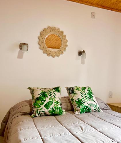 a bedroom with a bed with two pillows at Cabañas Rincón Andaluz in Puerto Iguazú