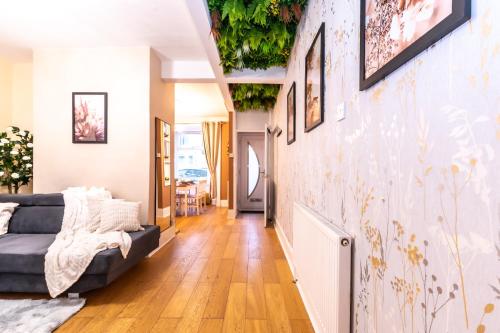 a living room with a couch and a wall with plants at Open Mind Property - Hot Tub , Garden , 3 Bedroom in Portsmouth