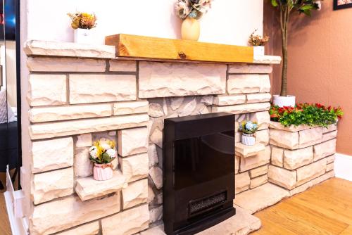 a stone fireplace with a tv in a living room at Open Mind Property - Hot Tub , Garden , 3 Bedroom in Portsmouth