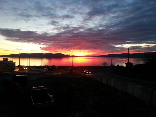 a sunset over a body of water with a car at BC Bikers Welcome Apartments in Senj