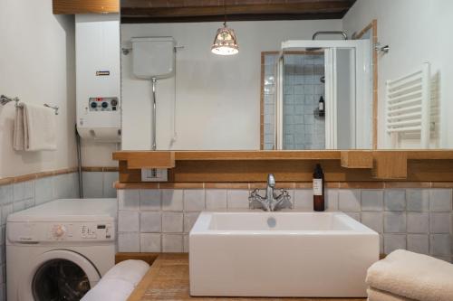 a bathroom with a sink and a washing machine at Le Dimore by Borgo Tessile - Feronia in Orvieto