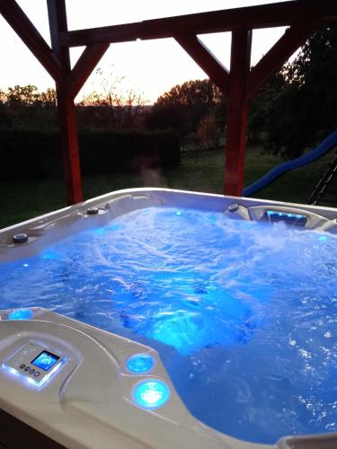 a hot tub with blue water in a gazebo at Chalupa Trosenka in Troskovice