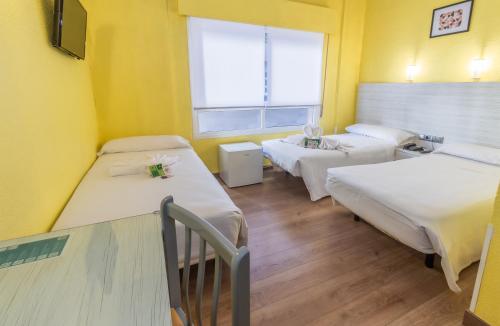 een ziekenhuiskamer met 3 bedden en een raam bij Hotel Universal Murcia in Murcia