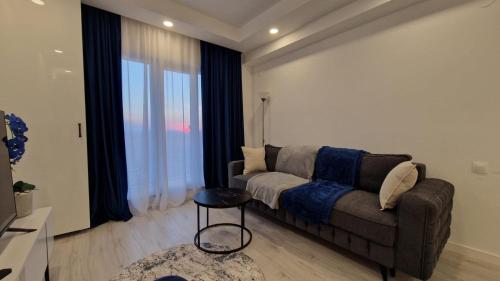 a living room with a couch and a large window at Sapphire Suite #pool&parking #Cosmopolis in Ştefăneştii de Sus