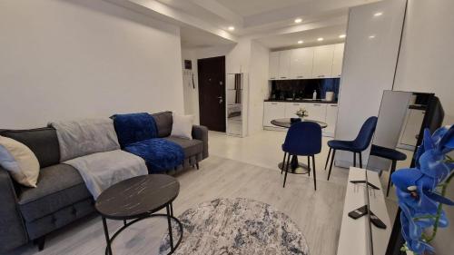 a living room with a couch and chairs and a kitchen at Sapphire Suite #pool&parking #Cosmopolis in Ştefăneştii de Sus