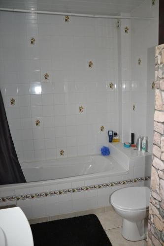 a bathroom with a white tub and a toilet at Mafadel in Cluny