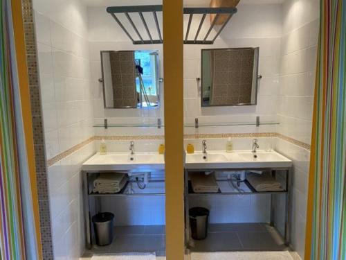 een badkamer met twee wastafels en twee spiegels bij La Fresnée chambres d'hôtes in Mosles