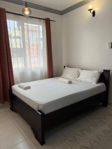 un letto in una stanza con una grande finestra di Zaniti a Mombasa