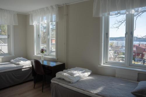 een kamer met 2 bedden, een bureau en ramen bij STF Sigtuna Vandrarhem in Sigtuna