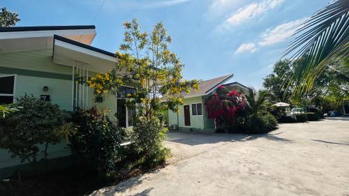 a house with trees and plants in front of it at ออมทรัพย์ รีสอร์ต in Ban Lam Ta Sao Tai