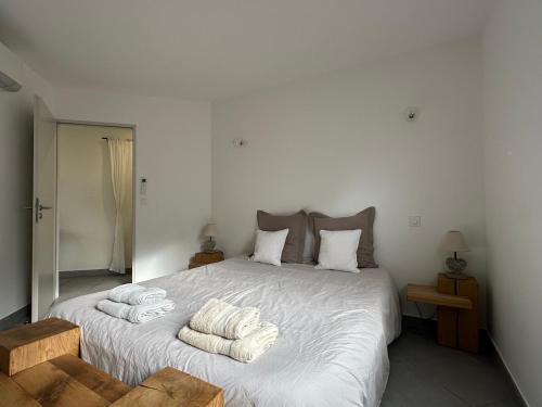 a bedroom with a large white bed with towels on it at Résidence Le Vénusia - 2 in Port-Vendres