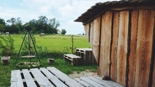 a wooden building with a bench next to a field at Shelter i sansehave in Præstø