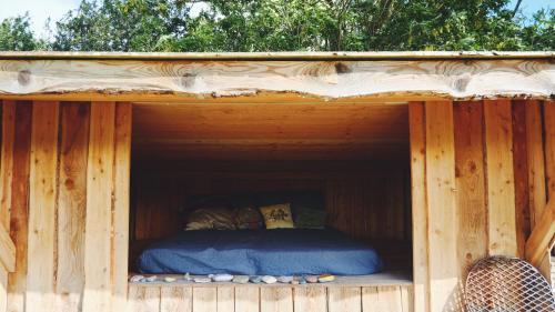 a bed in the inside of a wooden house at Shelter i sansehave in Præstø