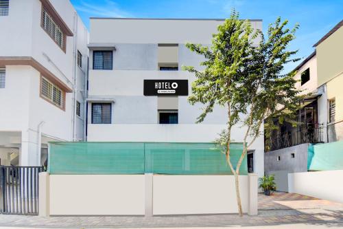 een gebouw met een bord voor een boom bij Hotel O Western Avenue Pune Formerly Happy Stay in Méribel Village