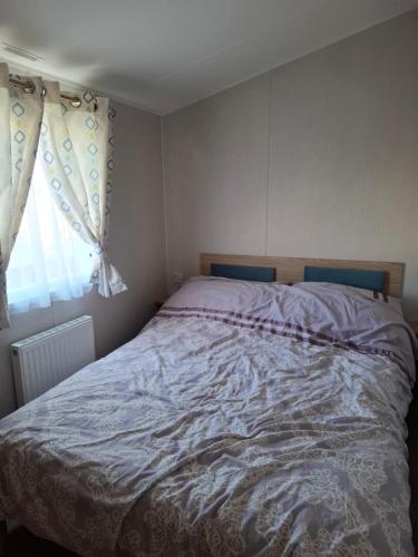 a bedroom with a bed with a blanket on it at Life is Adventure in Great Clacton
