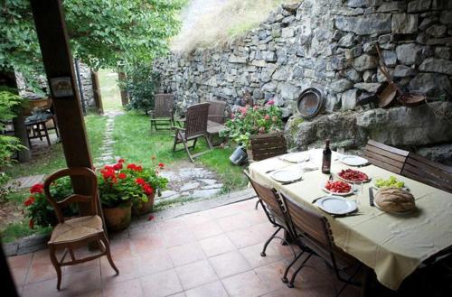 a table and chairs on a patio with a stone wall at Riojania Traditio Mountain in Munilla