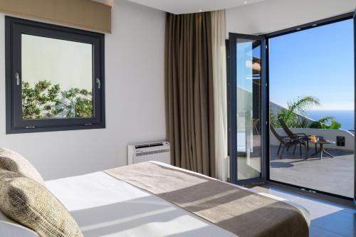 una camera d'albergo con un letto e un balcone di Secret Path Luxury Villas a Imerovigli