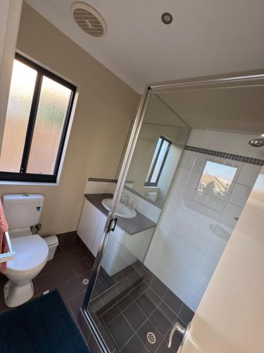 a bathroom with a shower and a toilet and a sink at Ocean Whisper in Wannanup