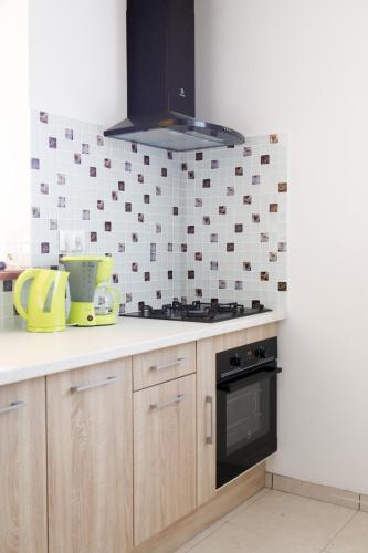 a kitchen with a stove and a tile wall at Kaïvivi in Le Marin
