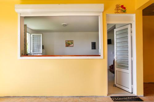 a door into a room with a yellow wall at Kaïvivi in Le Marin