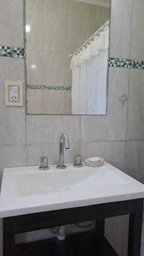 a bathroom with a white sink and a mirror at posada acevedo in Acevedo