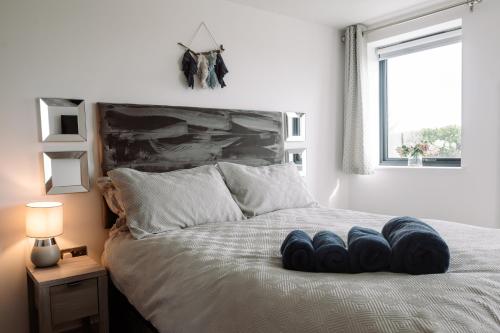 a bed with a bunch of pillows on it at Coast Beachfront GF 6 guests dog friendly apartment in Southbourne