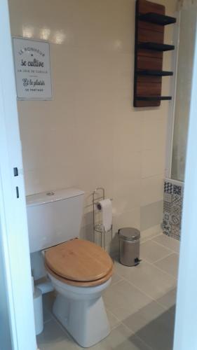 a bathroom with a toilet with a wooden toilet seat at LePré Apartment 93 in Le Pré-Saint-Gervais