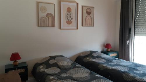 a bedroom with a bed and two lamps and pictures on the wall at LePré Apartment 93 in Le Pré-Saint-Gervais