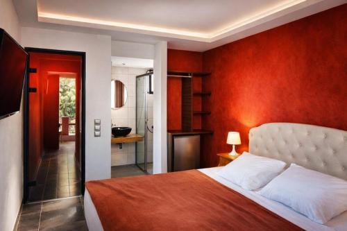 een slaapkamer met een bed en een rode muur bij Villa Park Luxury Rooms in Paralion astros