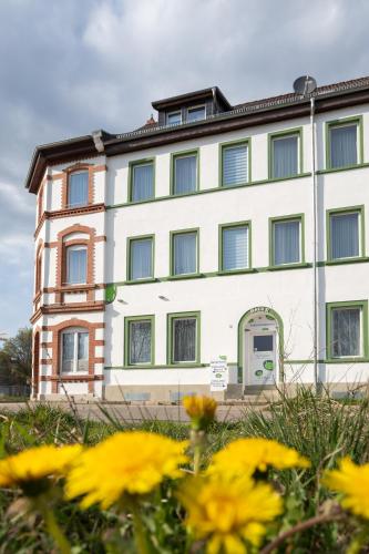a building with yellow flowers in front of it at Pension am Pollingpark Haus II in Dessau