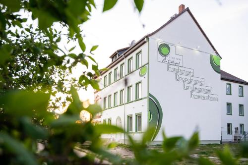 a white building with a sign in front of it at Pension am Pollingpark Haus II in Dessau