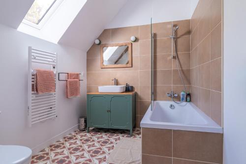 a bathroom with a sink and a bath tub at La Garencière - Les Fleurs in Champfleur