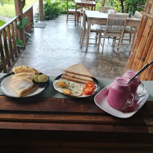 a table with two plates of breakfast foods and a drink at Stay Together in Tetebatu