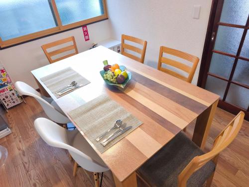 a dining room table with a bowl of fruit on it at みん民ハウス上浅田 in Hamamatsu