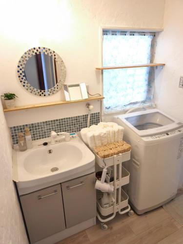 a bathroom with a sink and a washing machine at みん民ハウス上浅田 in Hamamatsu