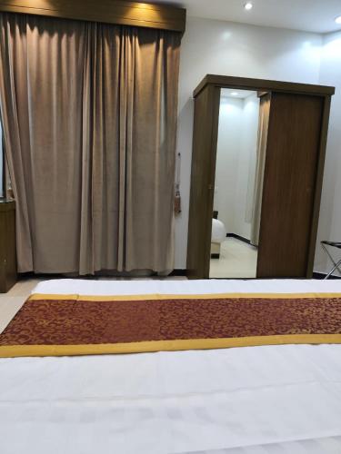 a bedroom with a bed and a large curtain at شقق همسات المخدومة in Khamis Mushayt