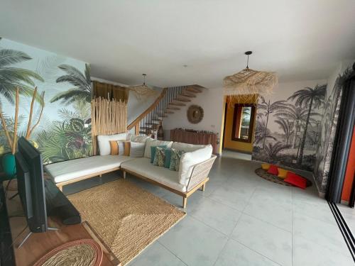 a living room with a white couch and a staircase at Villa Exotiqua Sunset in La Saline les Bains