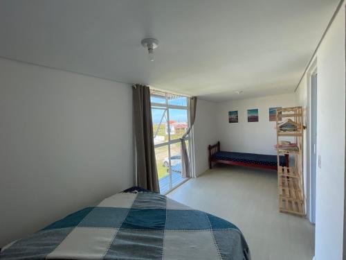 a bedroom with a bed and a large window at The Box Container House casa oceano in Imbituba
