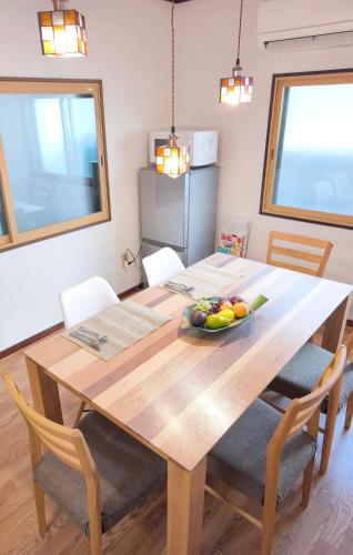 a dining room table with a bowl of fruit on it at みん民ハウス上浅田 in Hamamatsu